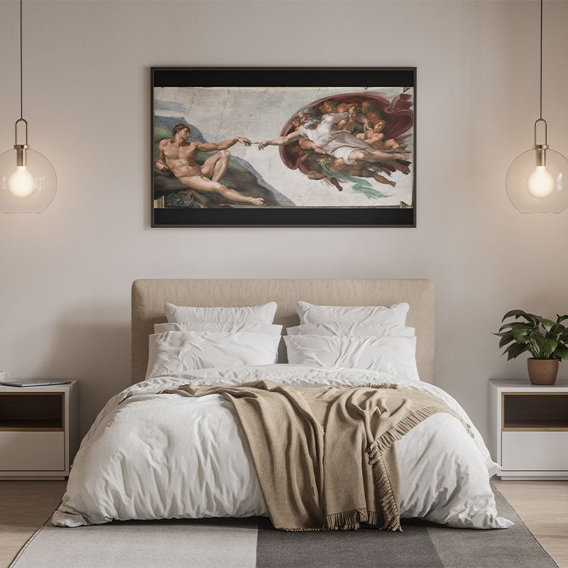 Quadro Decorativo A Criação de Adão com moldura preta pendurado acima da cabeceira de uma cama.