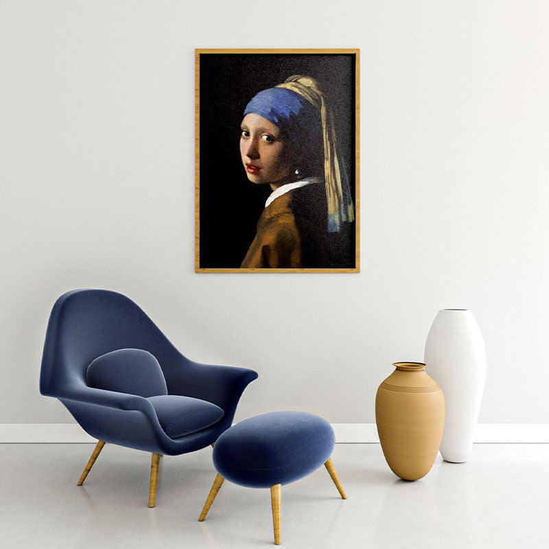 Quadro Moça Com Brinco De Pérola Pendurado Acima de Poltrona Azul.