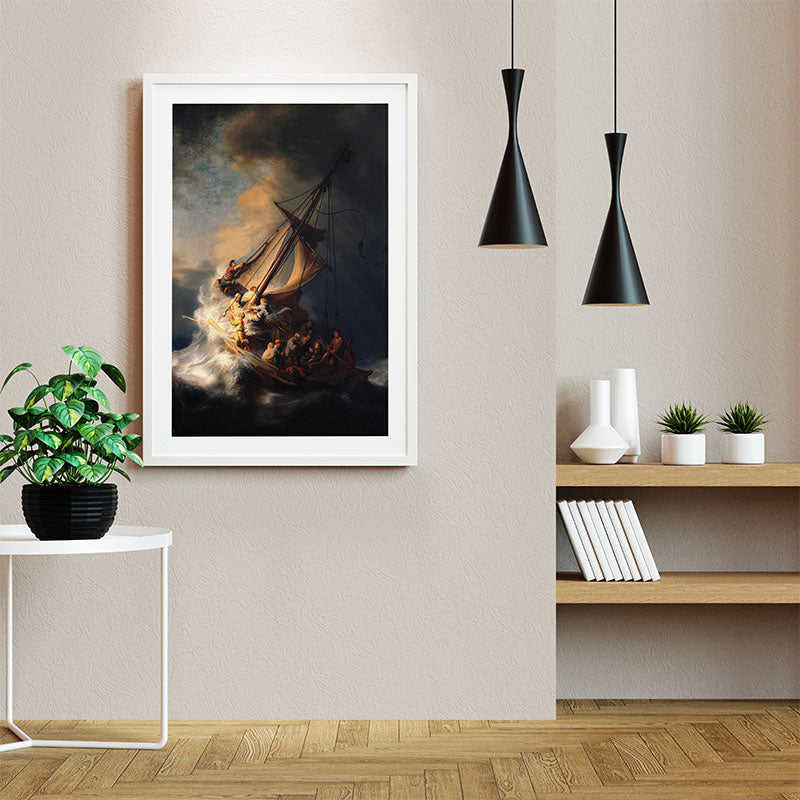 Quadro Tempestade no Mar da Galileia com moldura branca, decorando parede neutra ao lado de prateleiras, luminárias pretas e plantas.